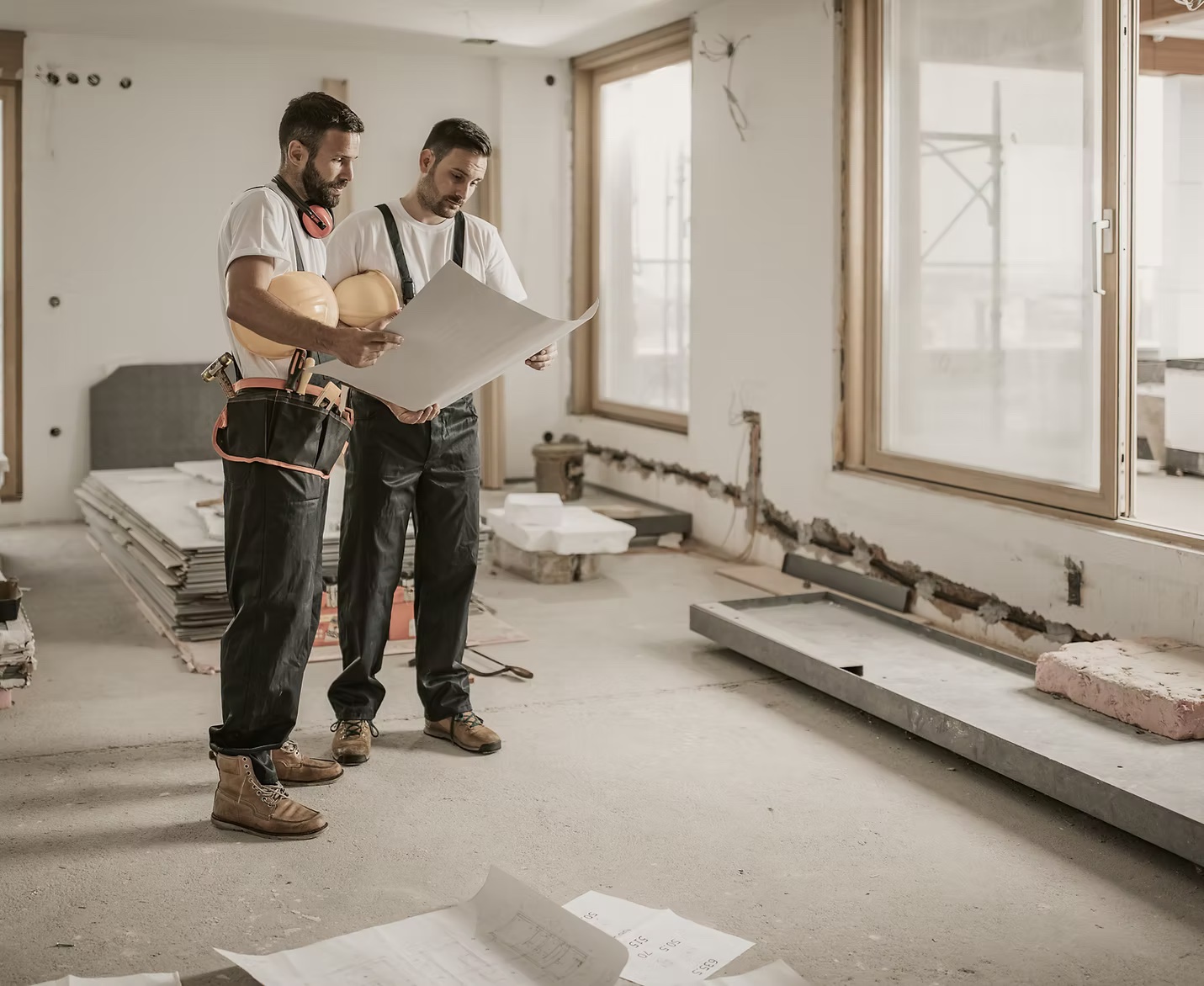 Two renovation professionals reviewing project plans inside a home
