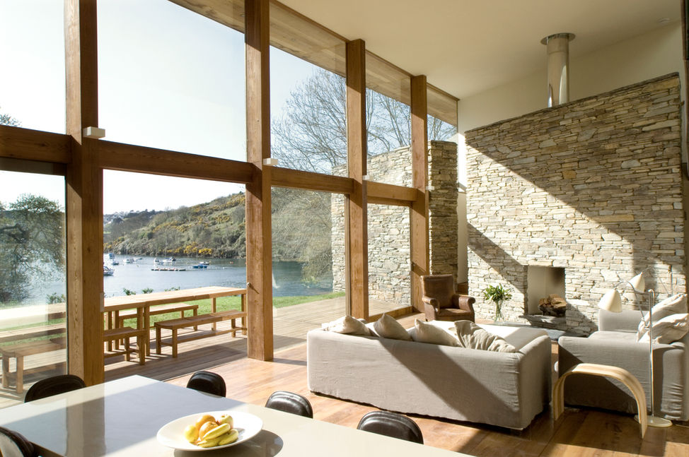 Bright lakeside living room with timber windows and stone fireplace